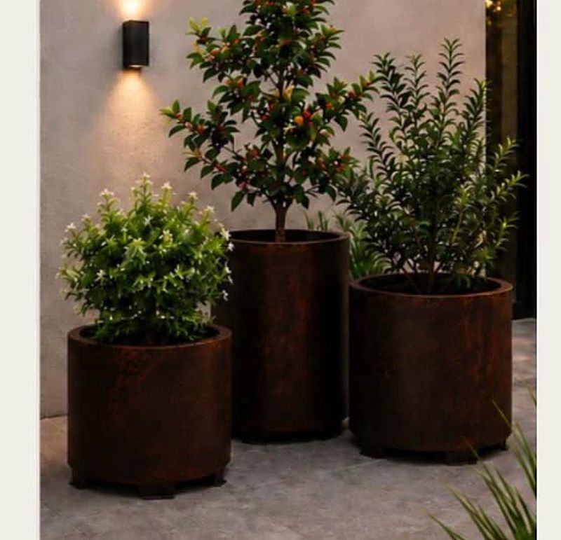 Set de macetas en acero corten junto a un muro exterior